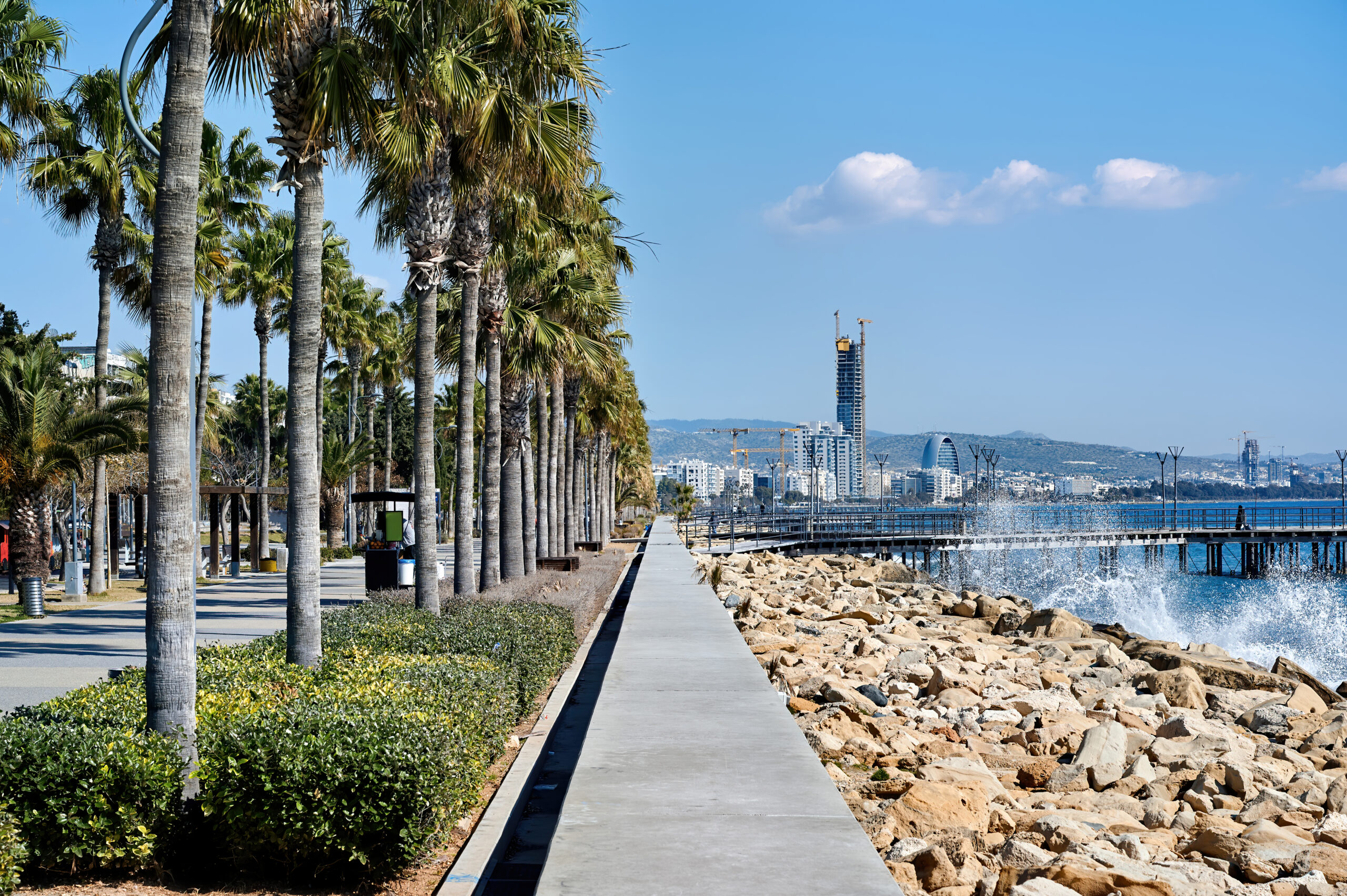 Vista del paseo marítimo de Sitges con el mar y las palmeras
